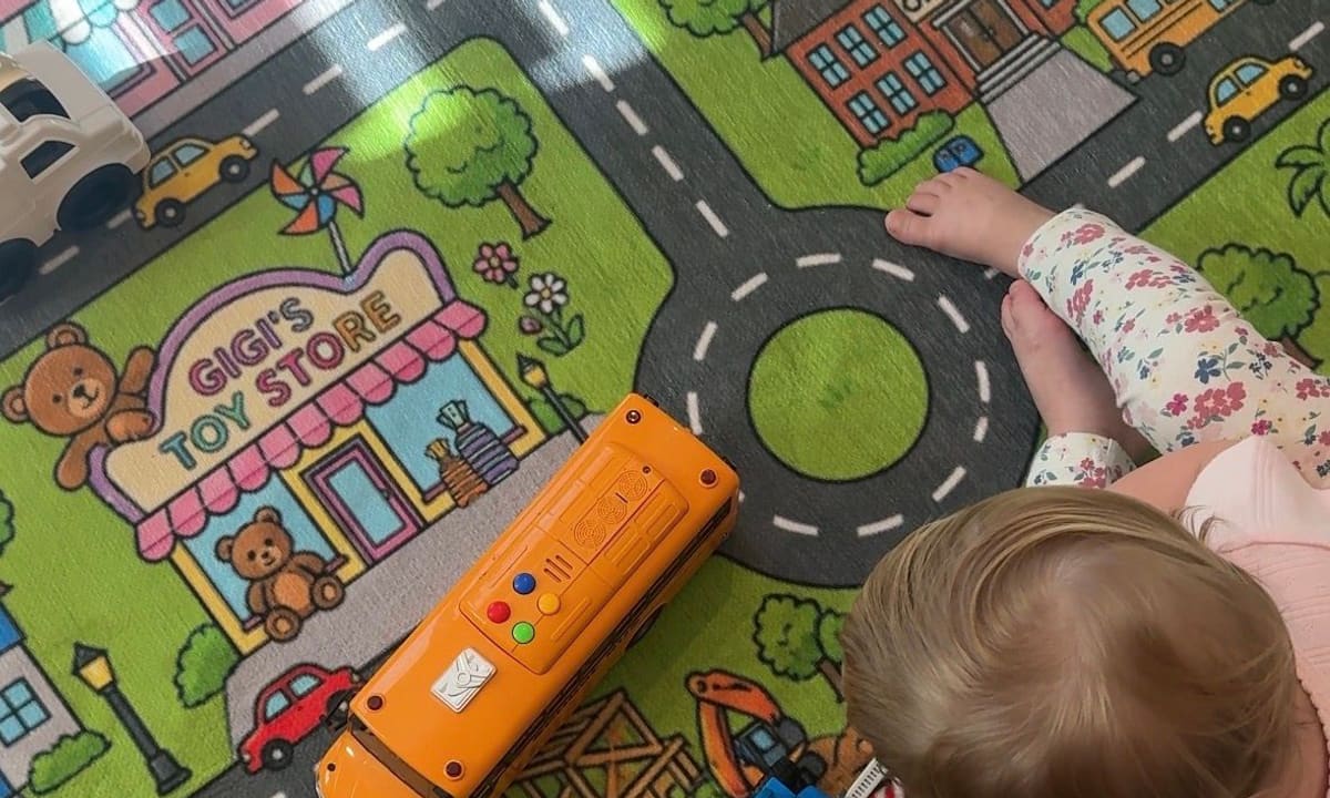 A toddler playing beside Gigi's Toy Store on a custom play mat