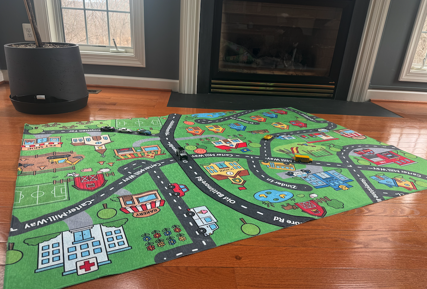Child playing on a personalized Little Roads play mat